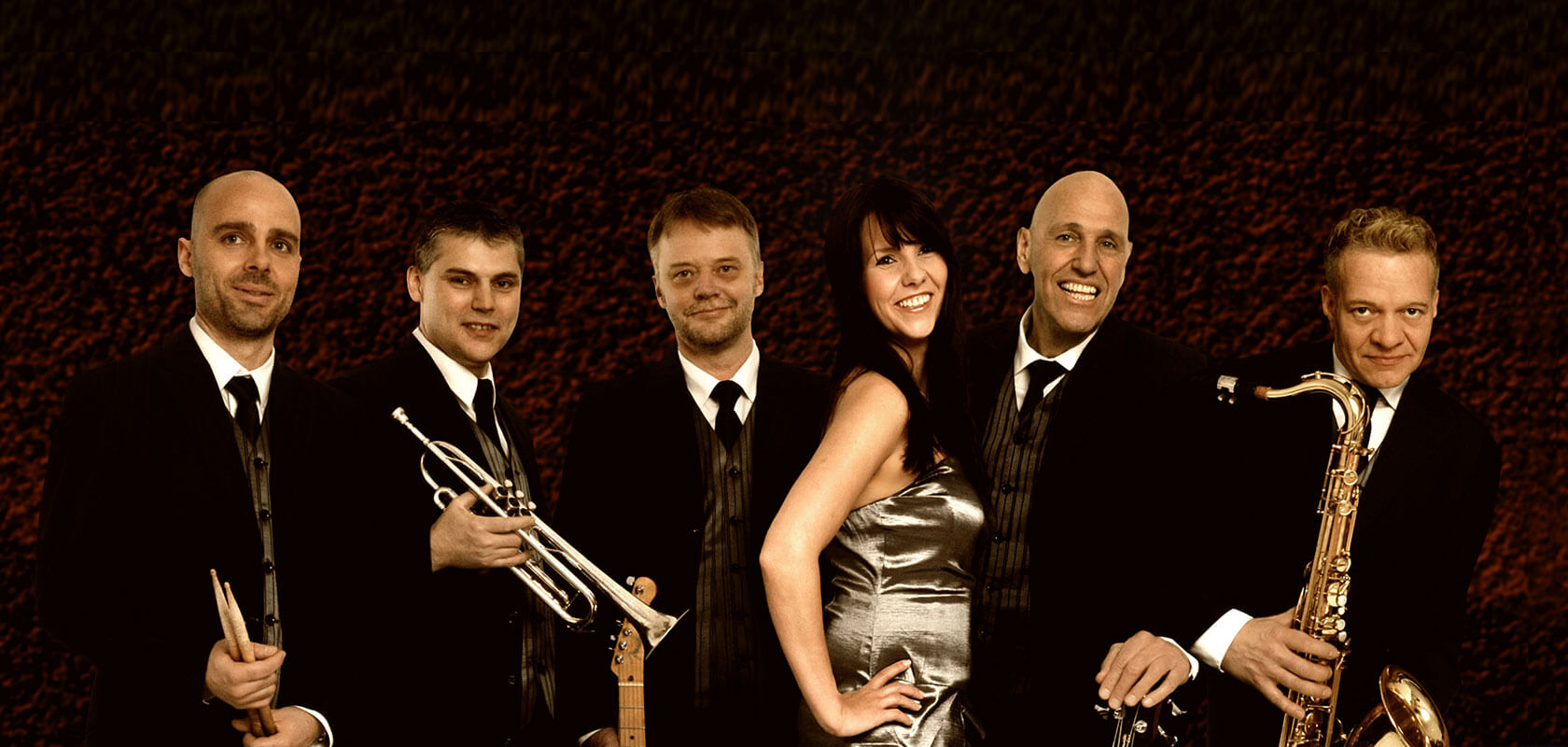 Hochzeitsband als Sextett – Schlagzeuger, Trompeter, Gitarrist, Sängerin, Bassist und Saxophonist